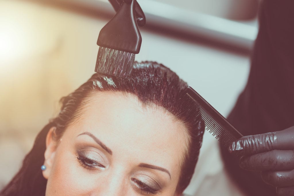 Hairdresser coloring client hair, light effect
